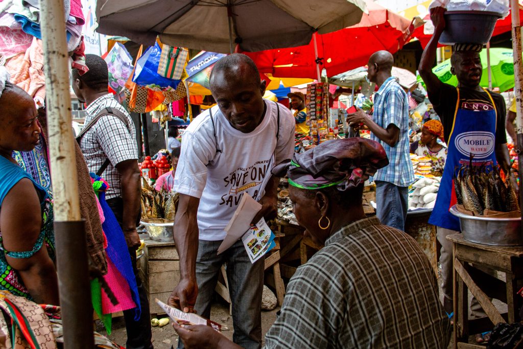 A market women being assisted by a CTAP market storm campaign team member.